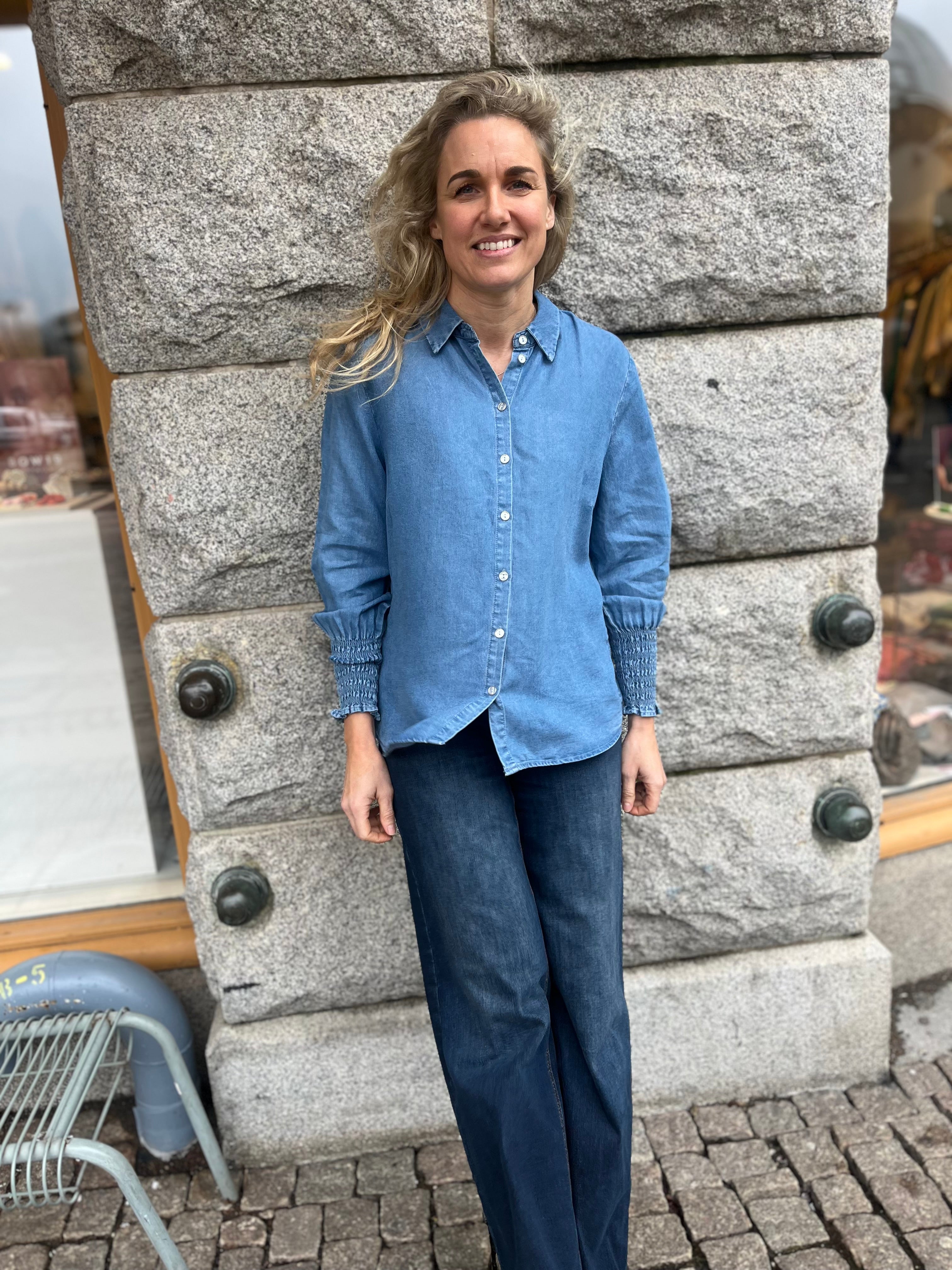 Blå jeans skjorta med resår detaljer vid ärmarna. Knäppning framtill.