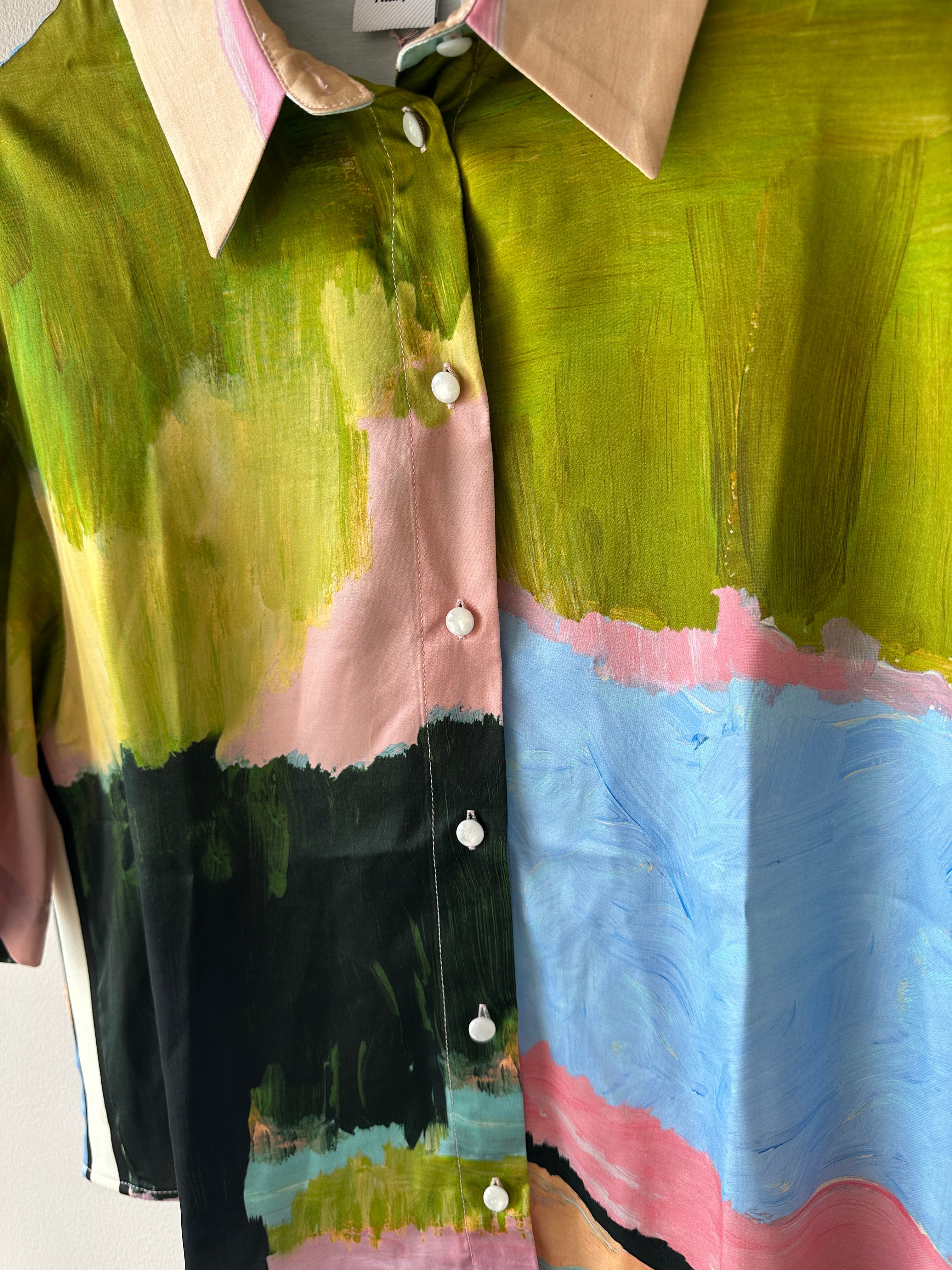 Skjorta i flertalet färger med kort ärm och knäppning framtill. 