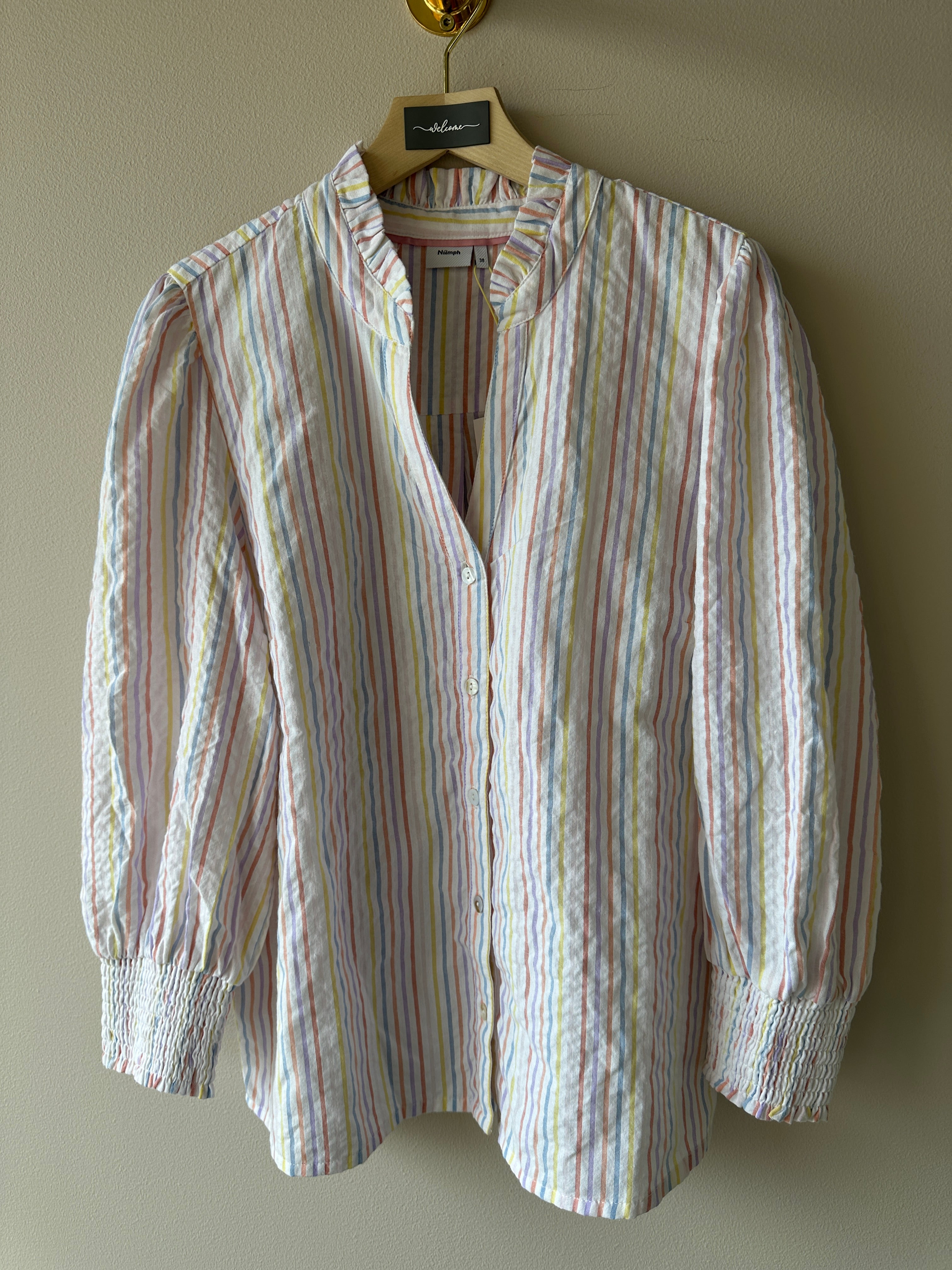 Blus med ränder i flertalet färger och dekorations kros på kragen.