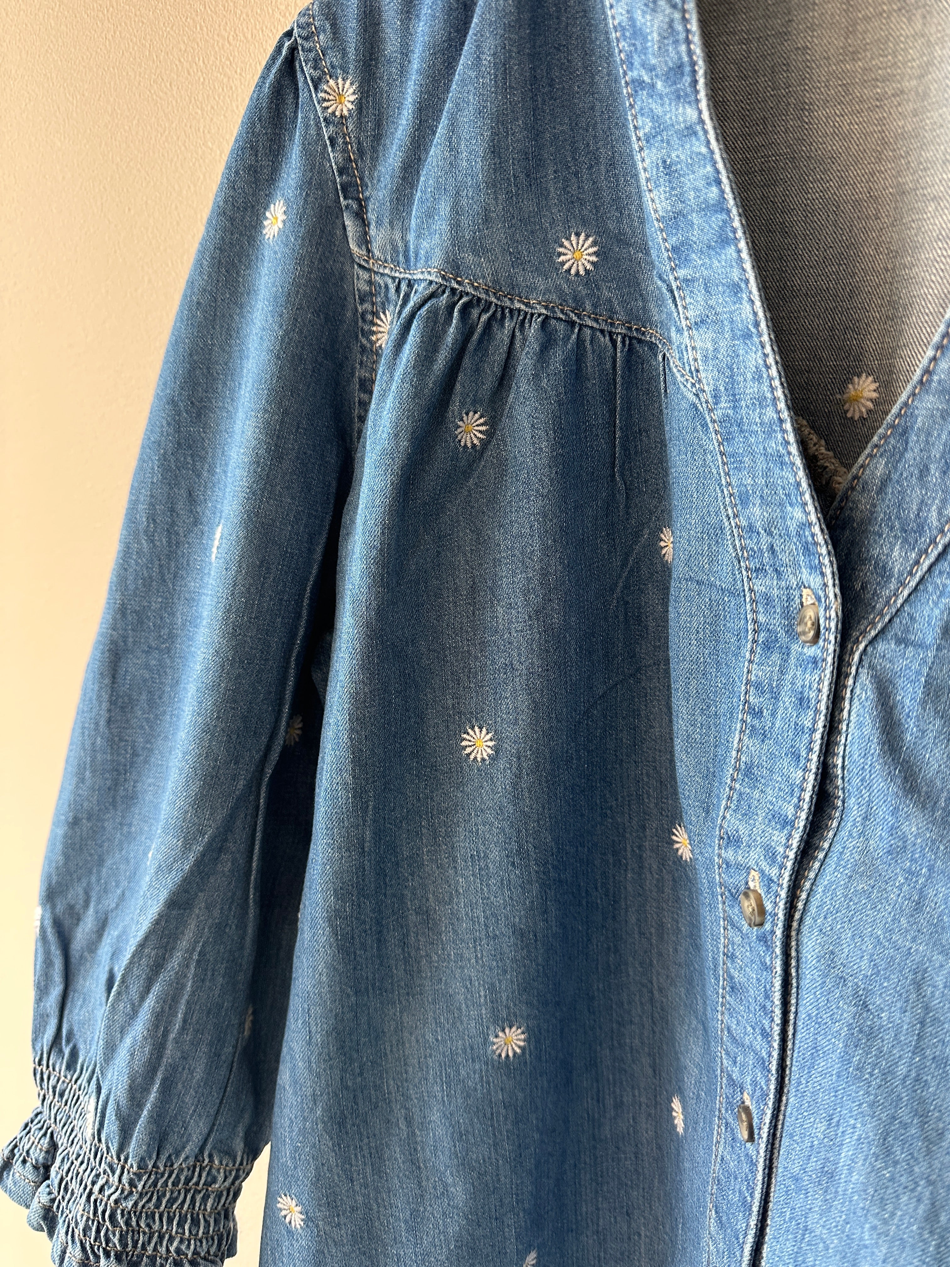 Jeans blus med små vita blommor. V-ringad med knappar.