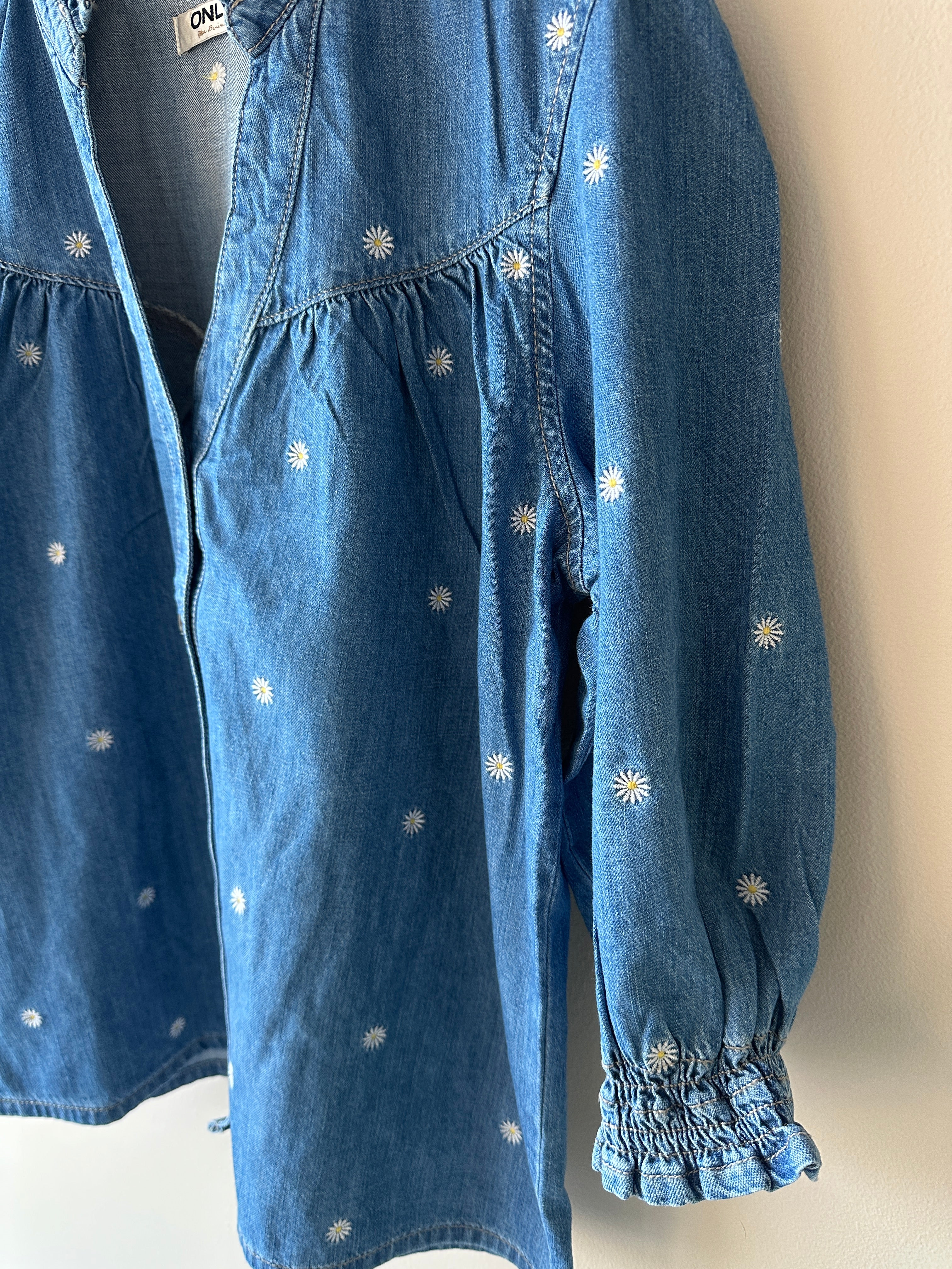 Jeans blus med små vita blommor. V-ringad med knappar.