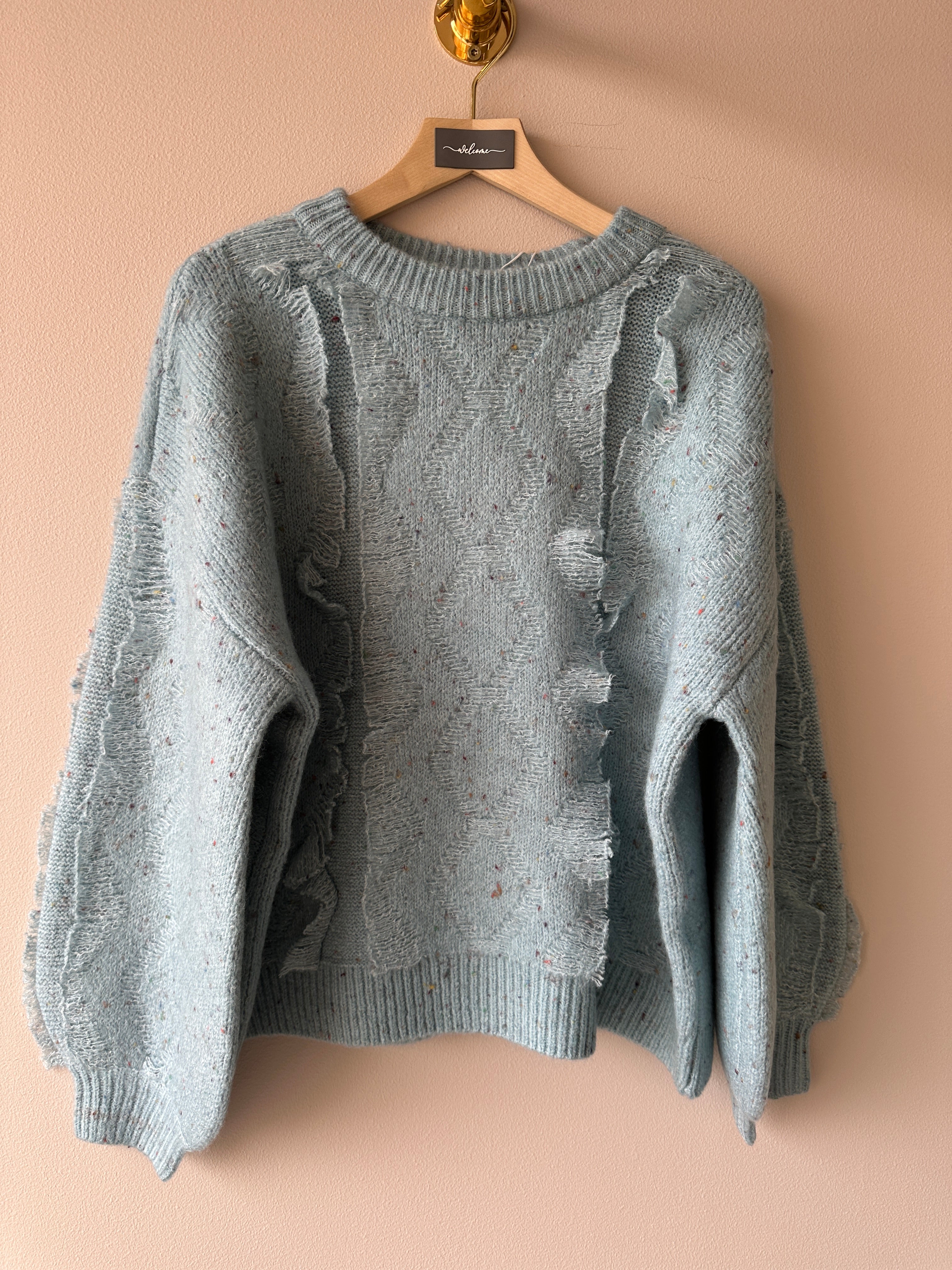 Stickad tröja en en blå grå färg. Långa ärmar och detaljer framtill.