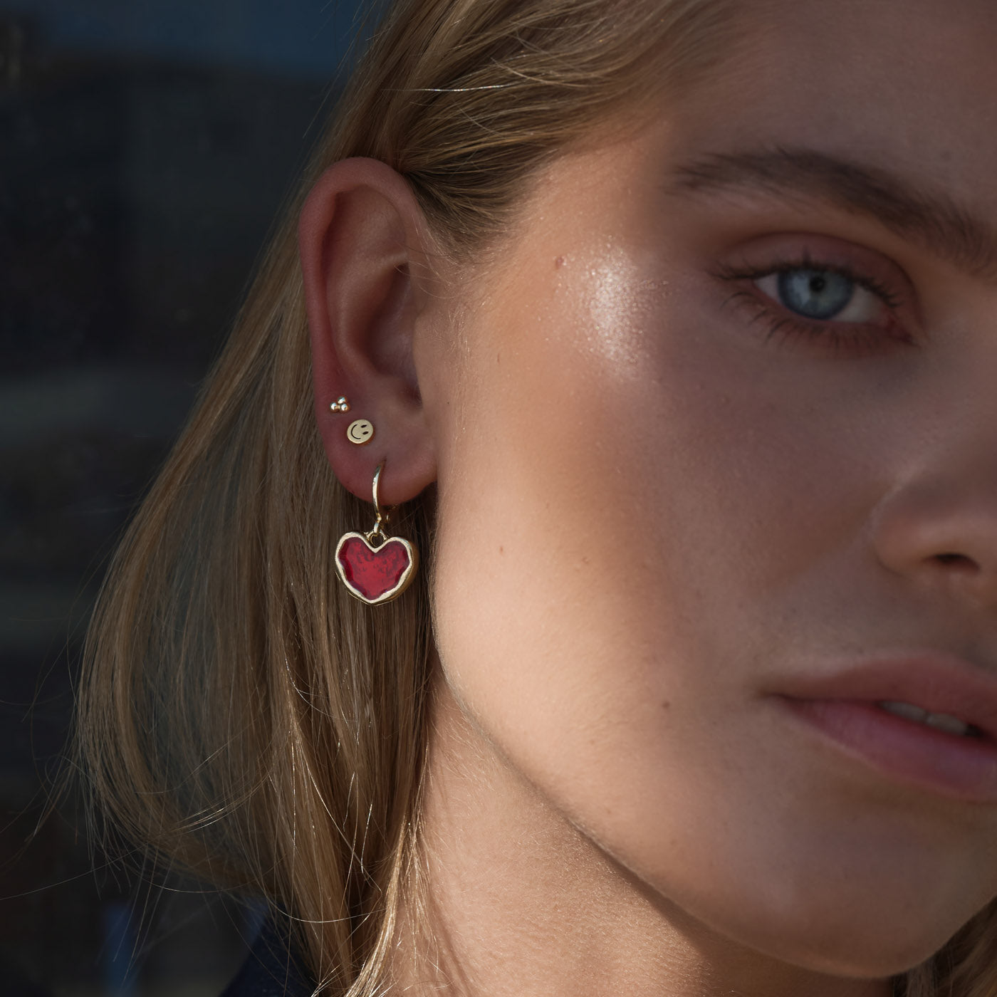 Agnes - 3 Balls Small Stud Earrings - BECCASIN STORE - Gold 3-ball stud örhänge earrings on ear with red heart charm smycke.