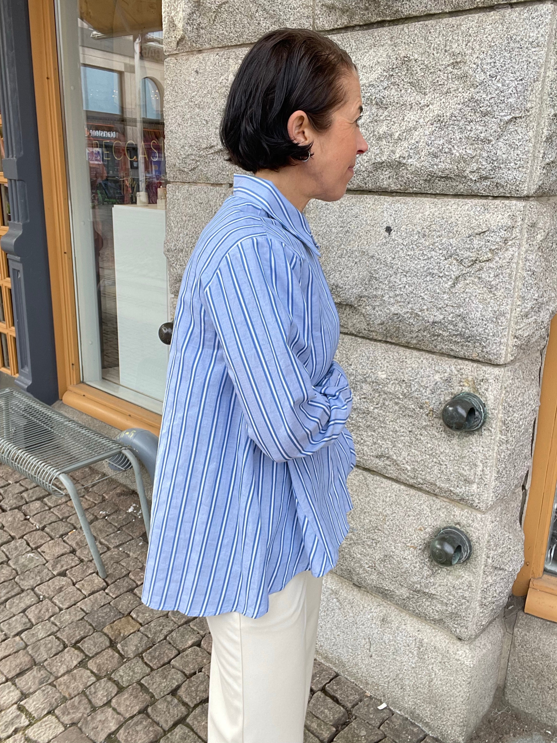 Blå vit randig skjorta med krage och dold knäppning. 