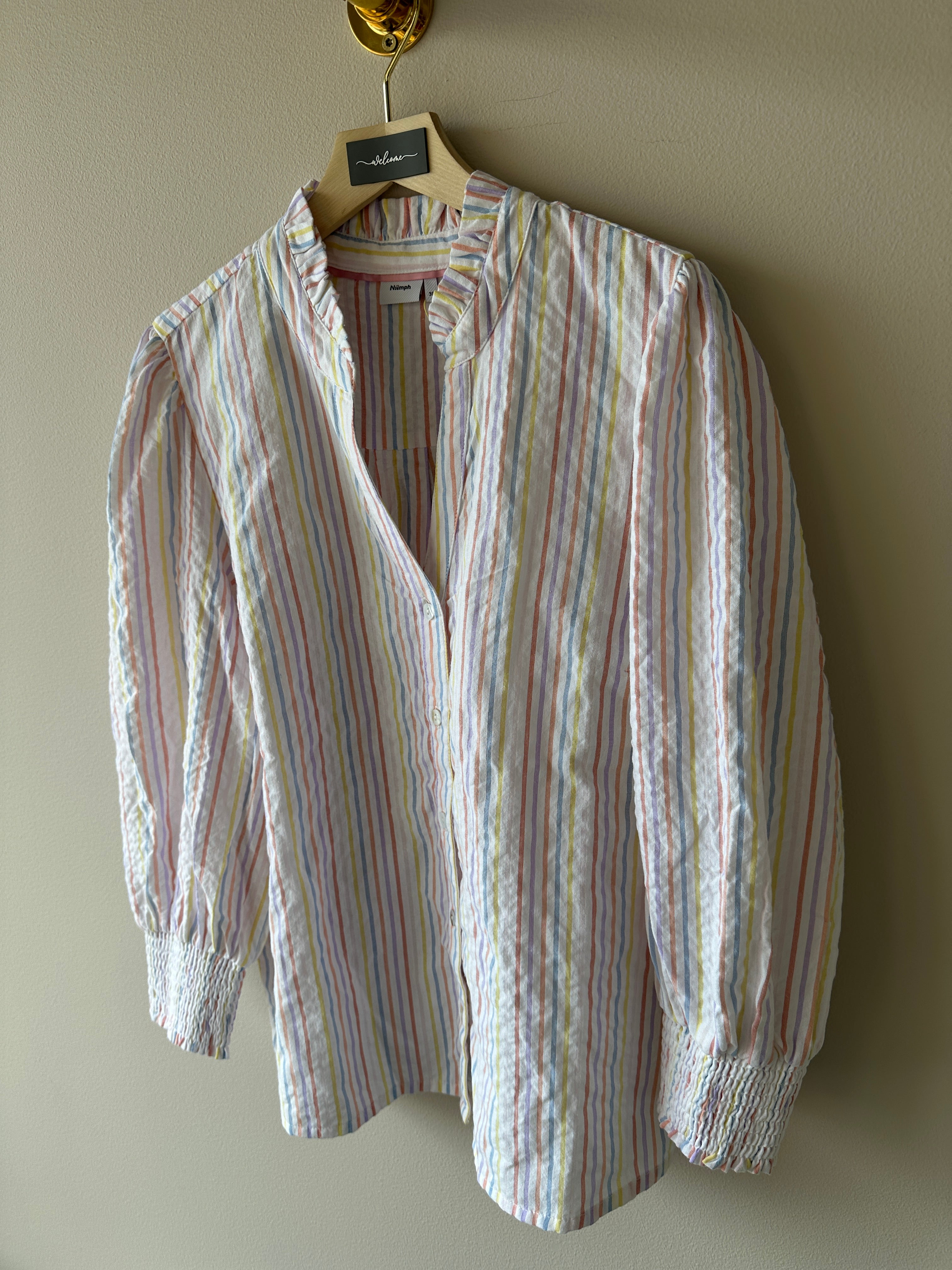 Blus med ränder i flertalet färger och dekorations kros på kragen.