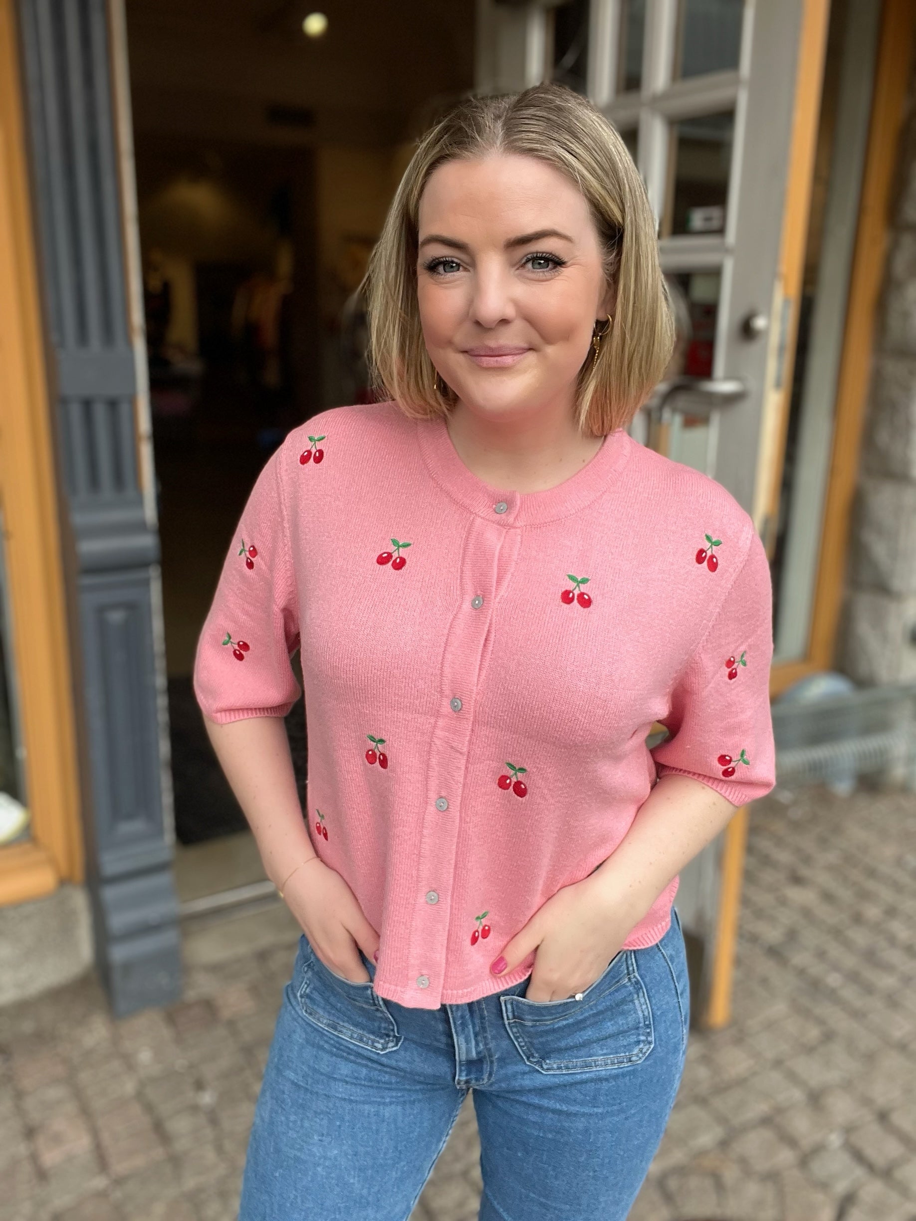 Rosa tunt stickad tröja med körsbär på. 