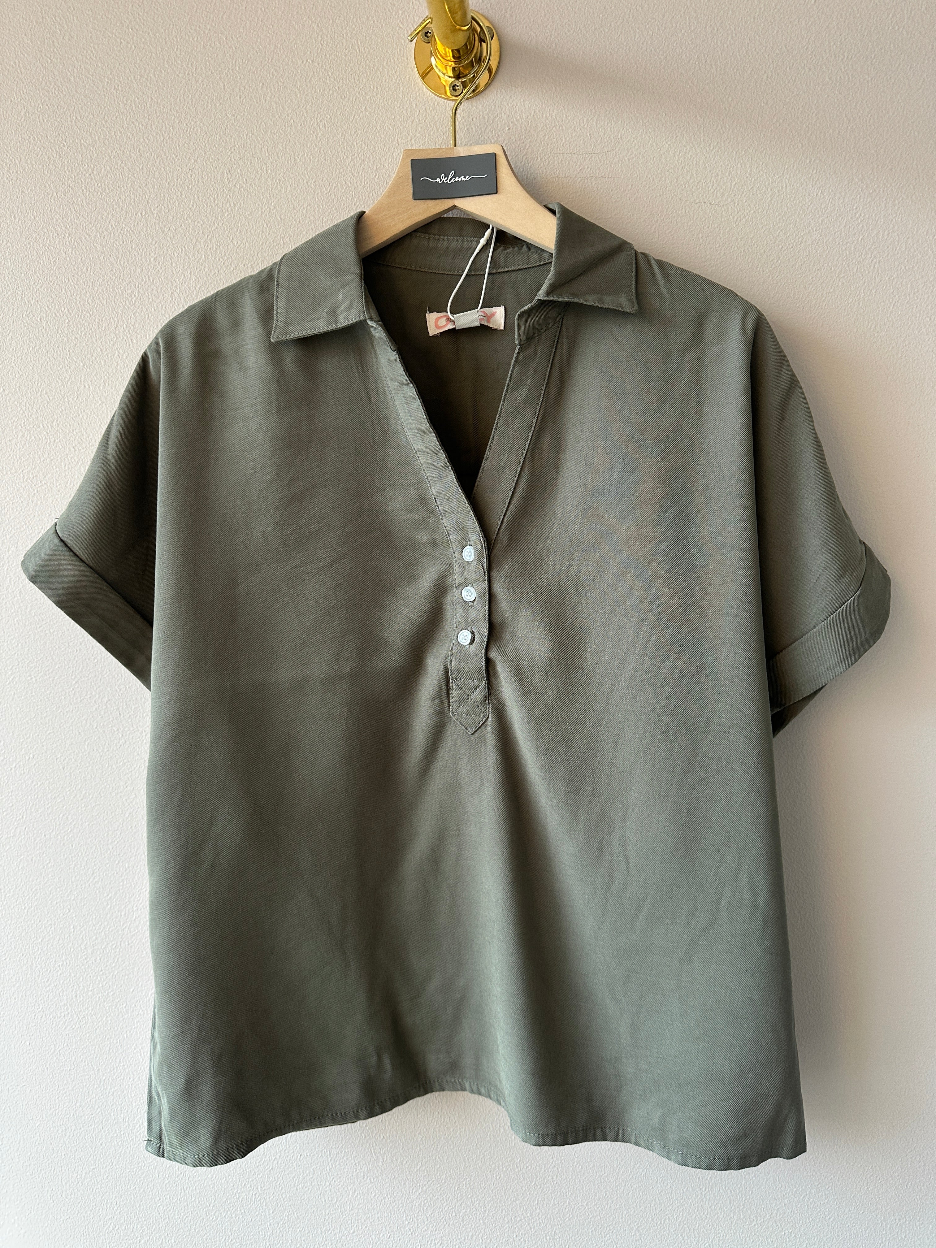 Oliv grön piké med korta ärmar och treknappar i v-ringningen. 