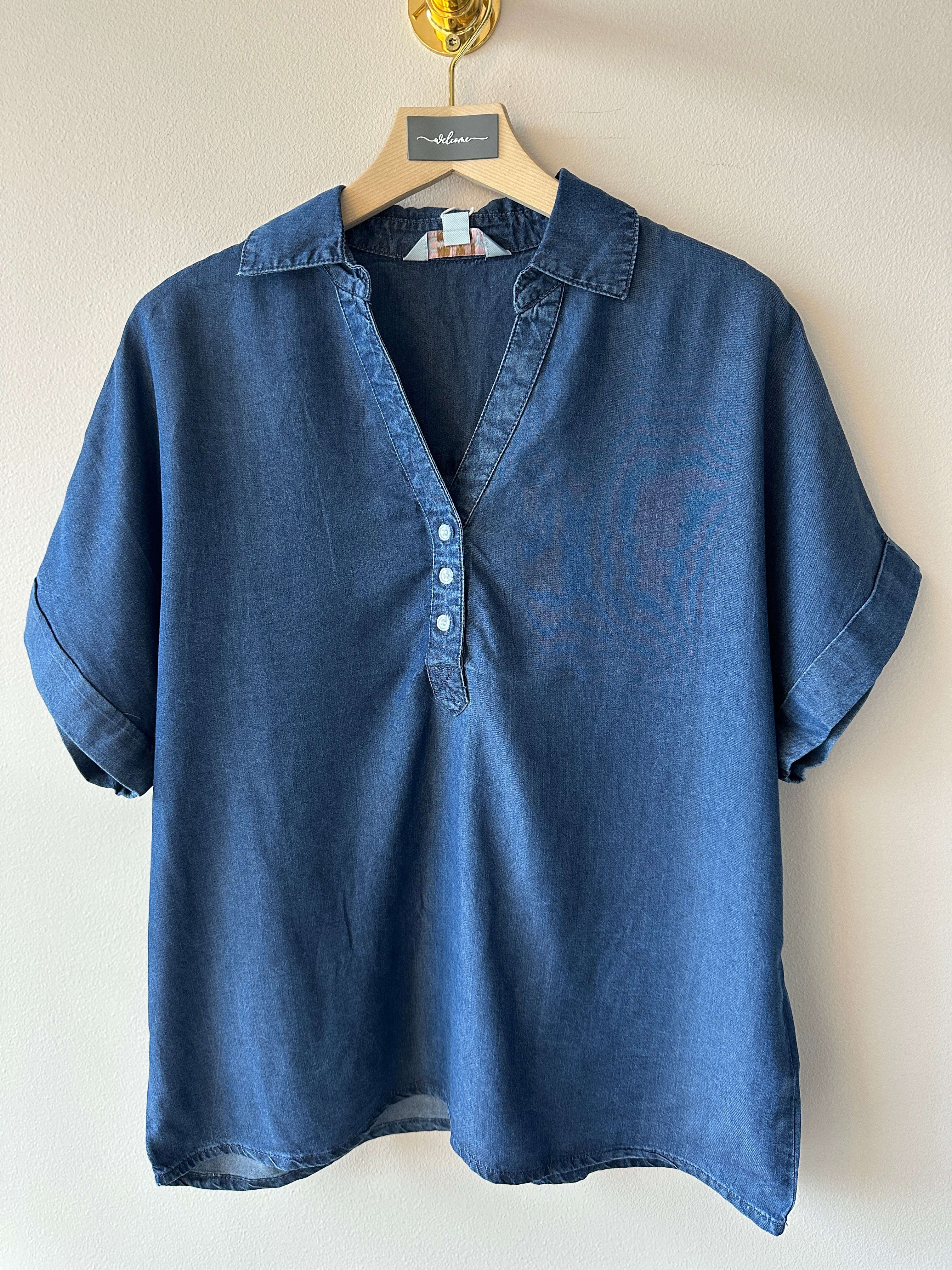 Blå jeans piké med kort ärm och tre knappar i v-ringningen. 