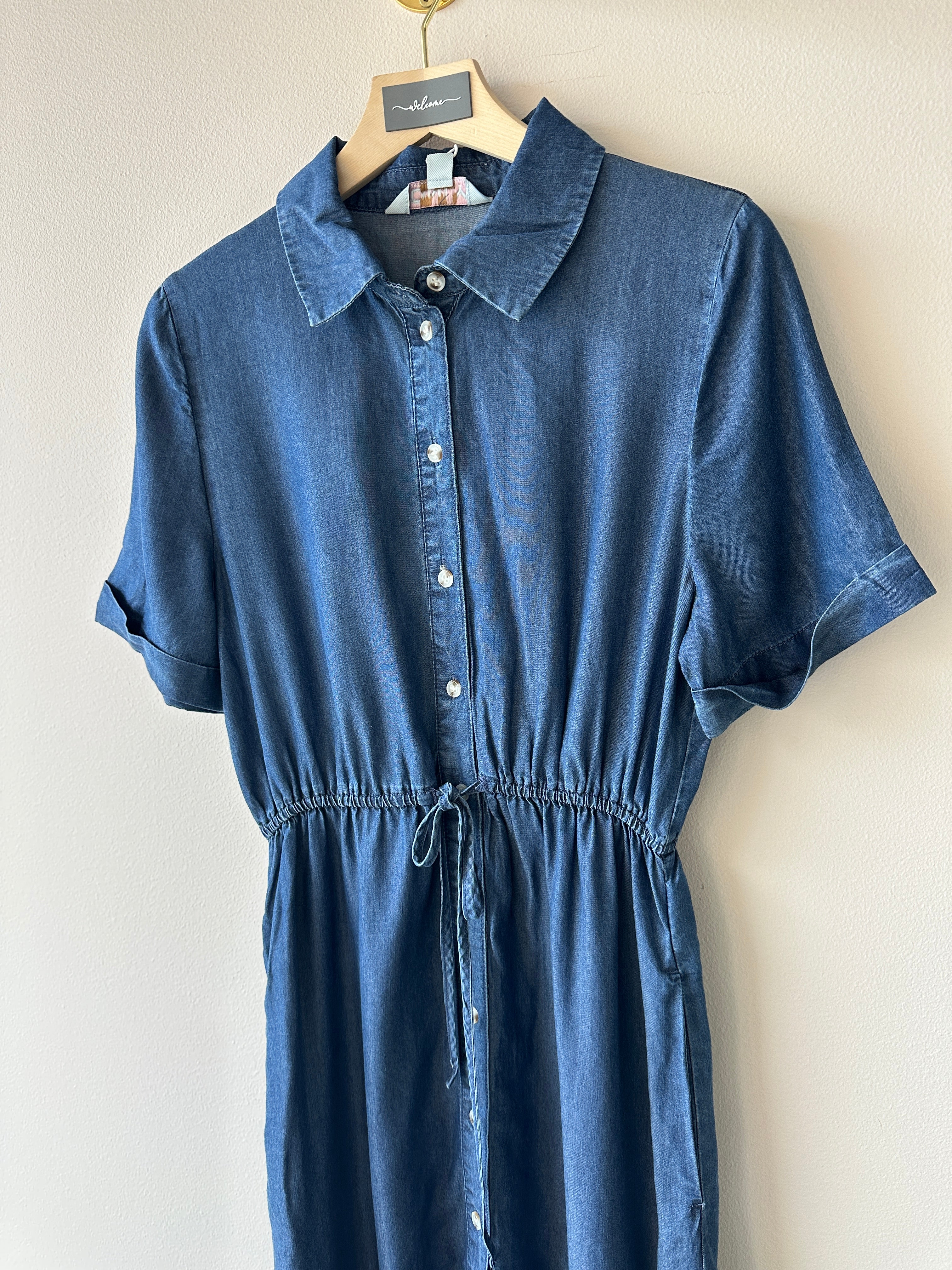 Skjortklänning i ett blått jeanstyg med knappar framtill och snörning i midjan.