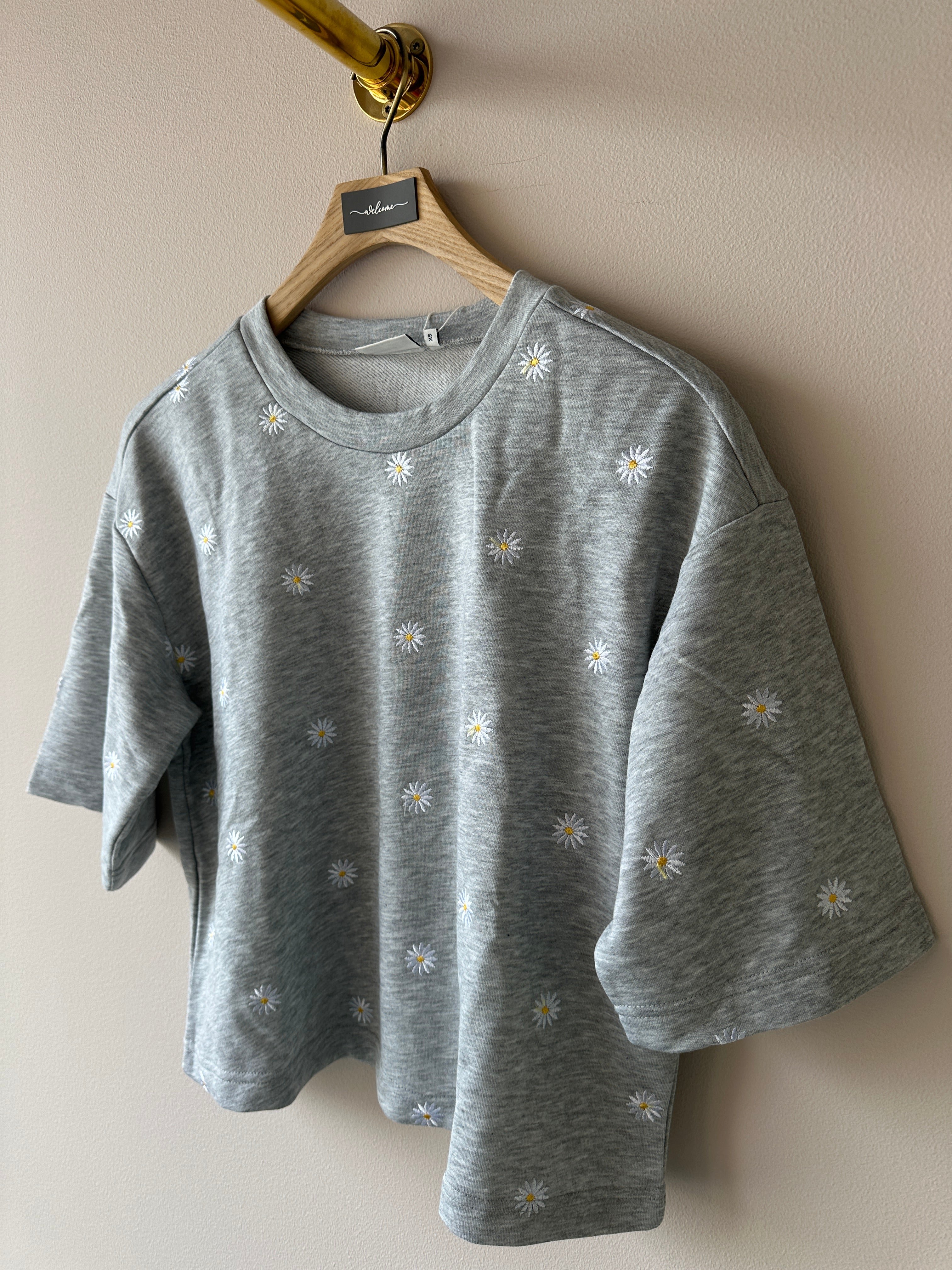 Sweatshirt med rund halsringning och 3/4 ärmar. Grå med vit/gula blommor.