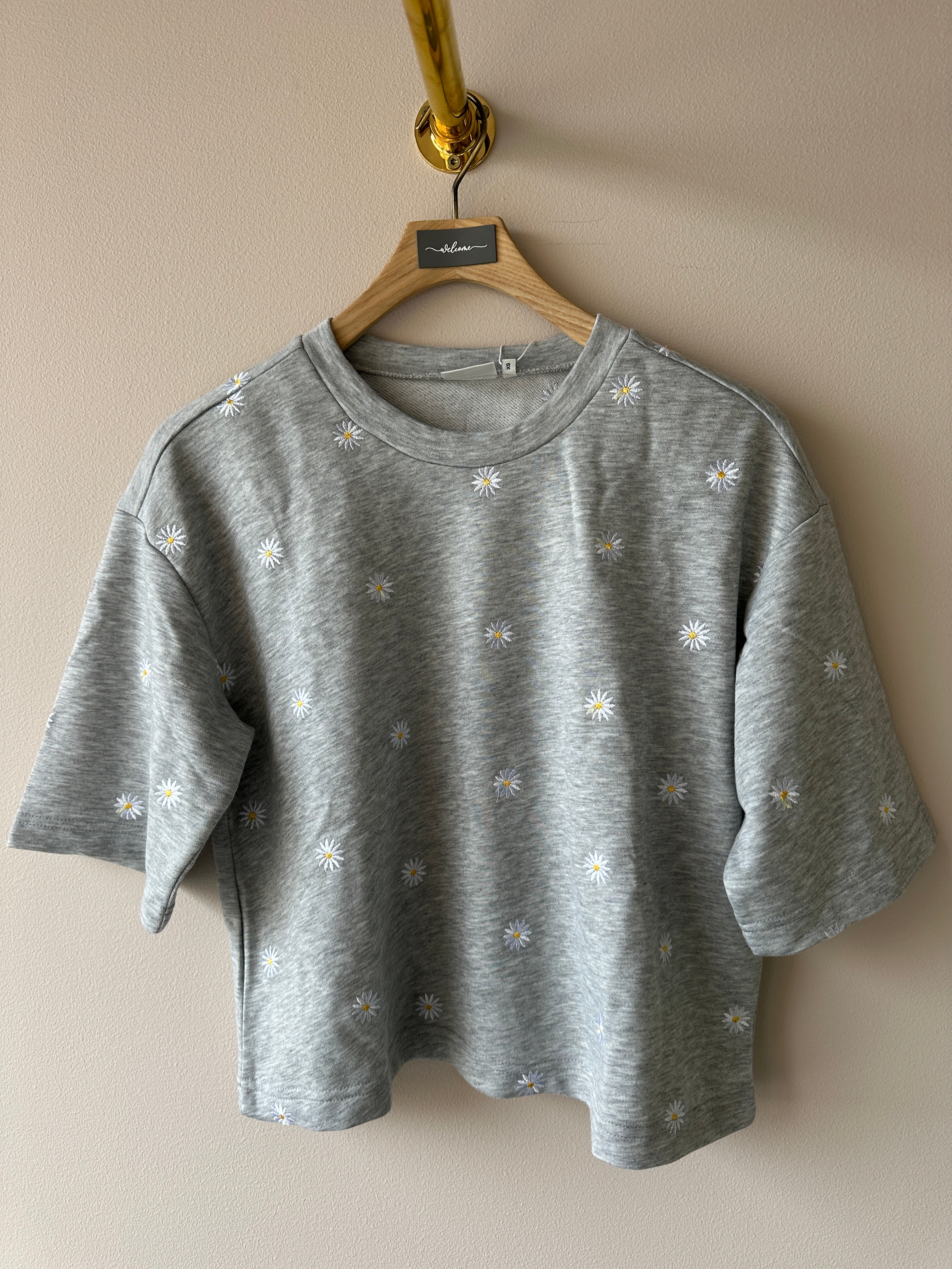 Sweatshirt med rund halsringning och 3/4 ärmar. Grå med vit/gula blommor.