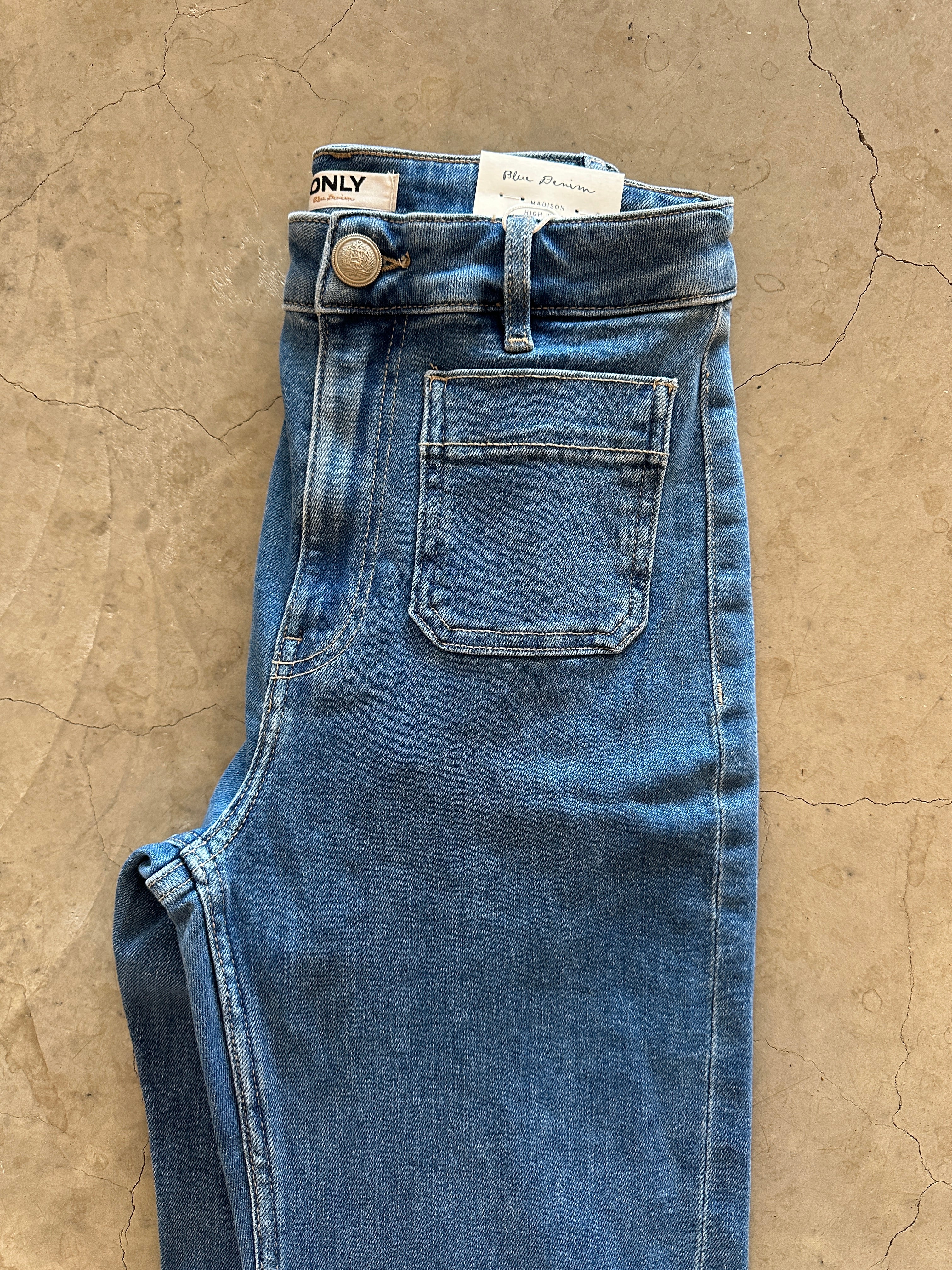 Onlmadison Hw Pocket Flared Light Blue Denim. Liggandes på golvet.