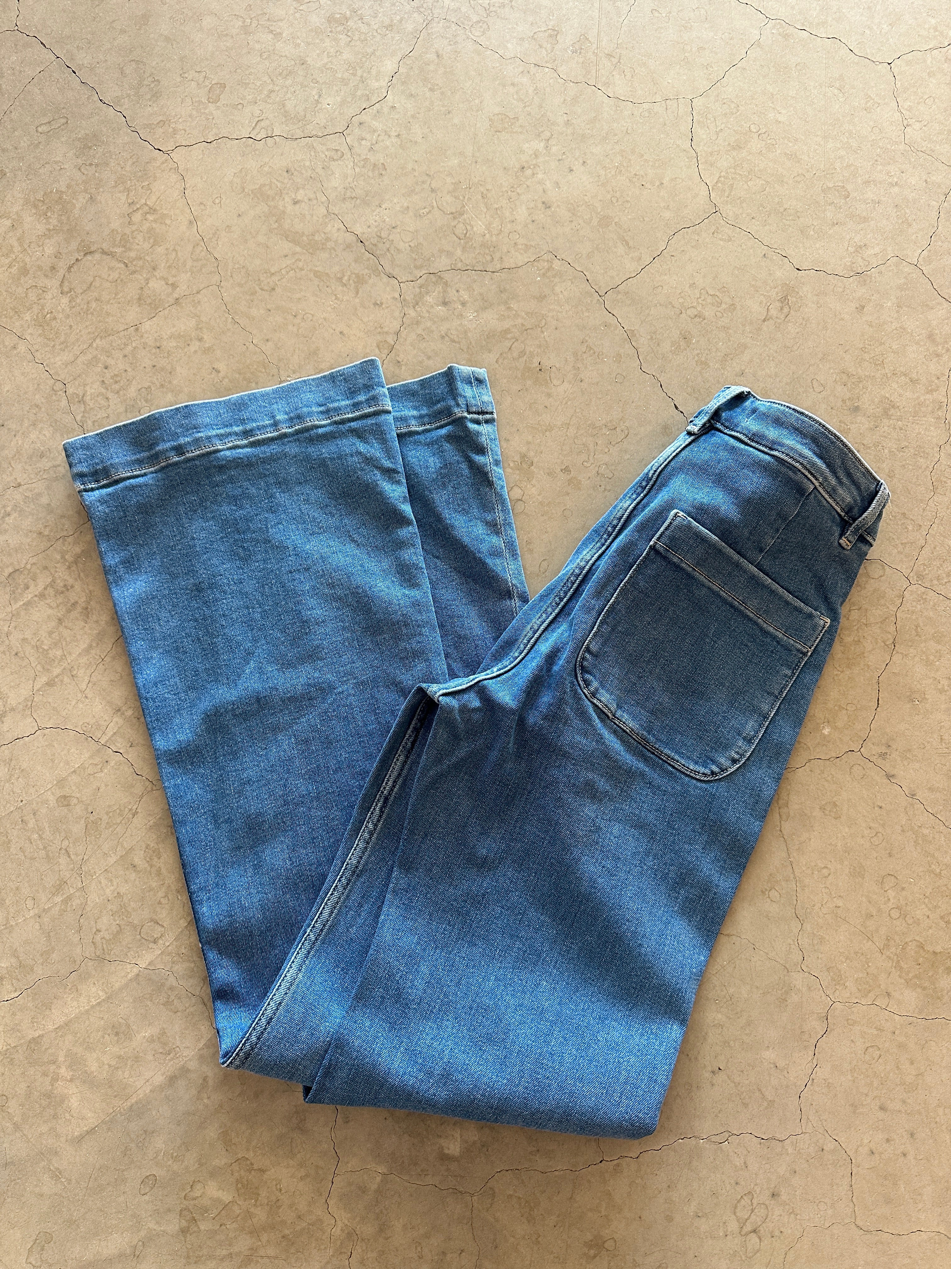 Onlmadison Hw Pocket Flared Light Blue Denim. Liggandes vikta på golvet.