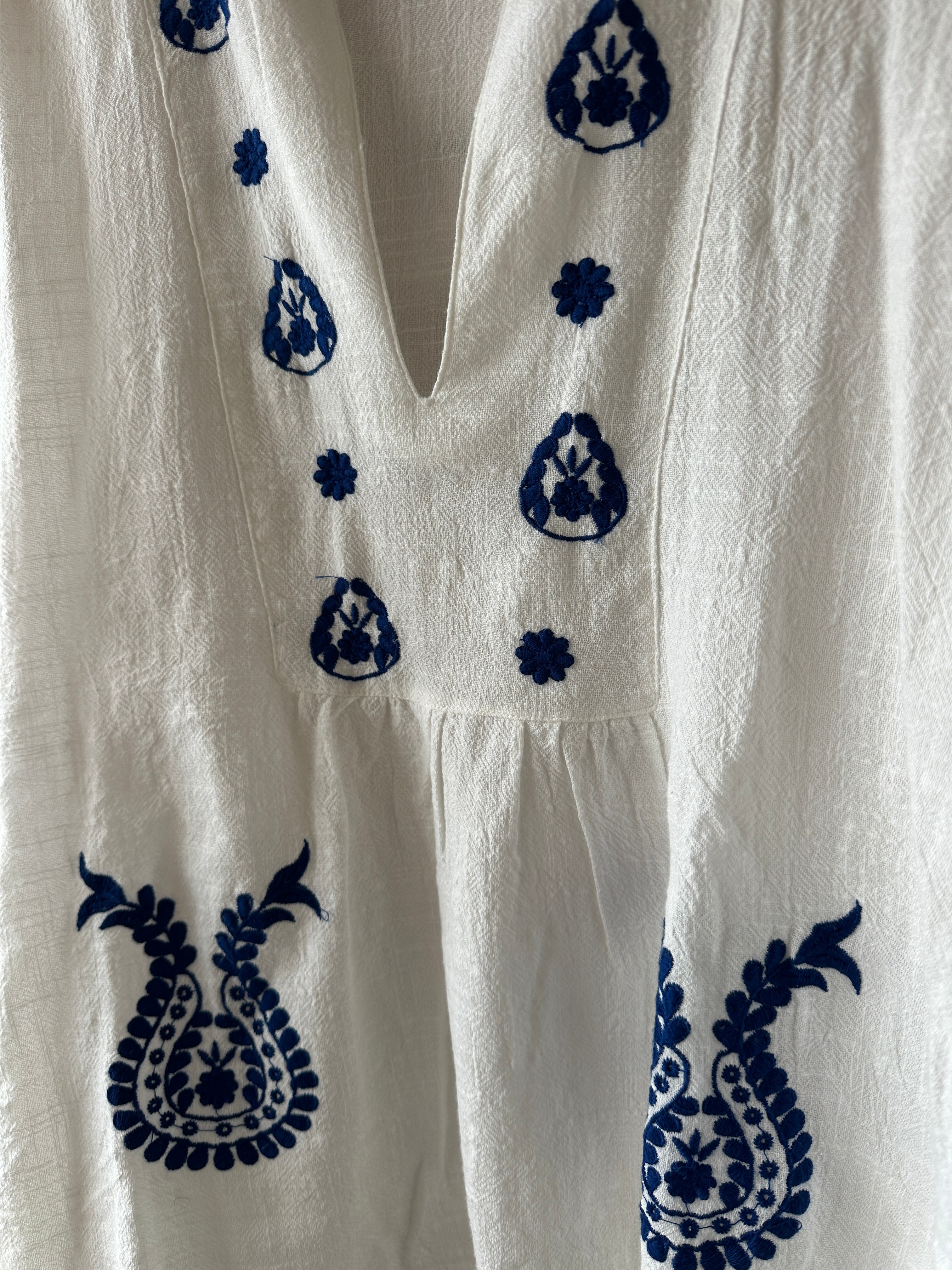 Vit blus med blåa broderi detaljer. 