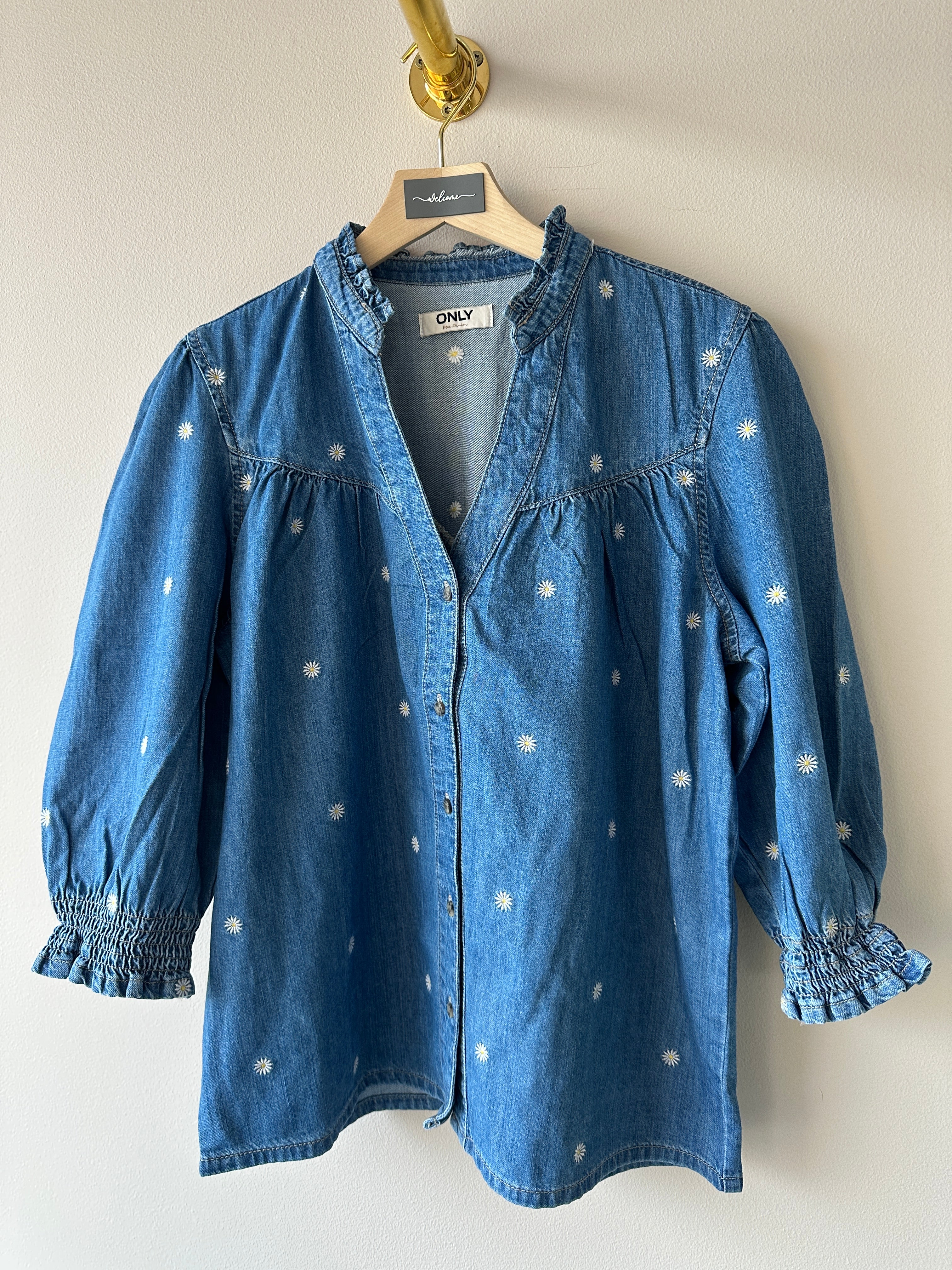 Jeans blus med små vita blommor. V-ringad med knappar.