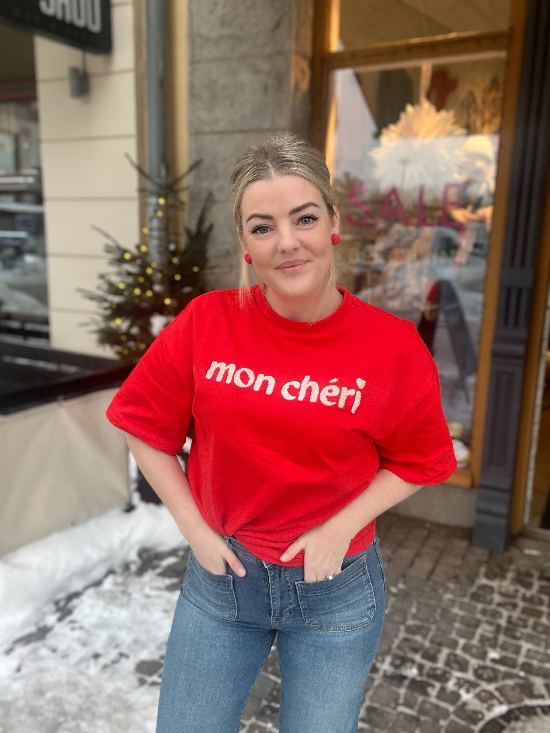 Pannasz Ss Sweatshirt Fiery Red - Fiery red oversized sweatshirt with white mon chéri text, styled with blue jeans outdoors. - BECCASIN STORE